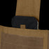 A close-up of a black ballistic plate partially inserted into the front pocket of a Condor Modular Operator Plate Carrier Gen II with a tan Velcro flap.